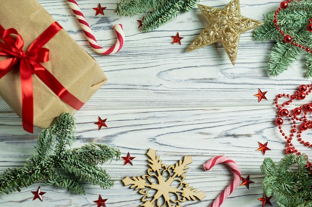 Decoraciones de fondo de marco de Navidad con ramas de abeto, presente, bastón de caramelo, copos de nieve y estrella