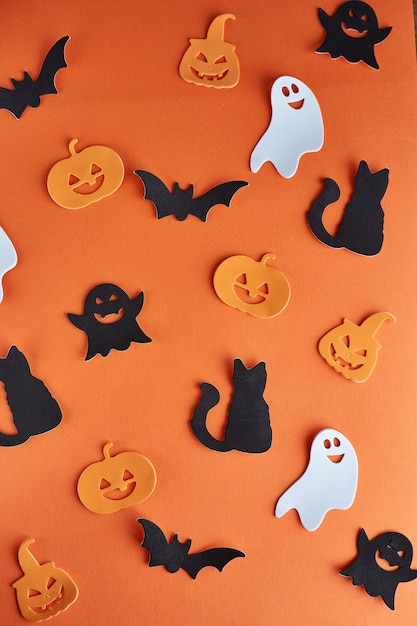 Decoraciones de Halloween, calabazas, murciélagos y fantasmas sobre fondo naranja