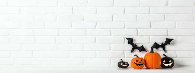 Foto decoraciones de halloween pared de ladrillo blanco con murciélagos y calabazas talladas