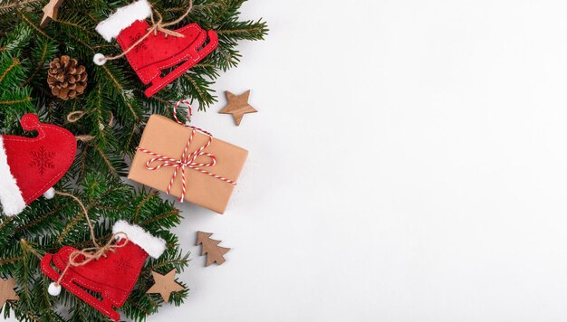 Decoraciones de Navidad hechas a mano patines de fieltro rojo juguetes con regalos y ramas de abeto verde de fondo