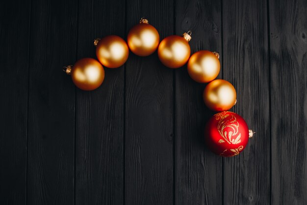 Decoraciones navideñas de colores en la mesa de madera negra. Bolas de Navidad sobre fondo de madera.