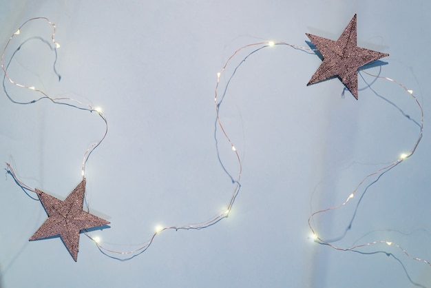 Decoraciones navideñas estrellas brillantes, guirnalda de Navidad sobre un fondo azul