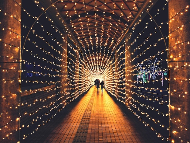 Decoraciones navideñas iluminadas en una pasarela cubierta