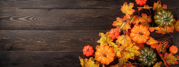 Decoraciones de otoño con calabazas y hojas sobre fondo negro