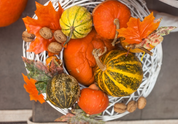 Decoraciones de otoño u otoño al aire libre con pimpkins y hojas en la canasta