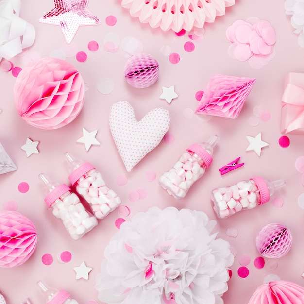 Decoraciones de papel rosa y blanco, pompones, dulces, corazones, regalos, confeti para Baby party. Concepto de cumpleaños. Endecha plana, vista superior