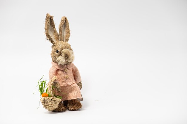 Decoraciones de Pascua Liebre Conejo de paja Conejo de juguete de Pascua hecho de paja con una cesta aislada sobre un fondo blanco