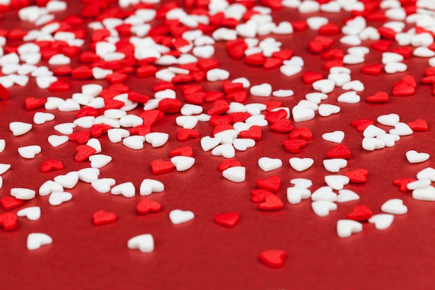 Decoraciones de postre hechas de dulces rojos y blancos en forma de corazón