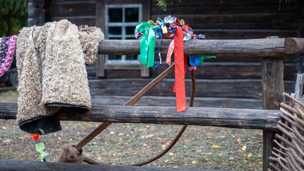 Decoraciones de pueblo de vacaciones Abrigo de piel y esqueleto de madera con corona de crax Ropa para interpretar el papel de una cabra en el festival de villancicos en el fondo de una antigua casa rústica