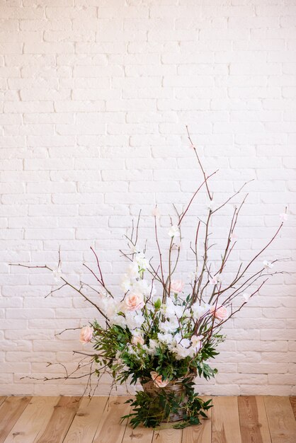 Decoraciones de ramas con hermosas flores rosas y blancas en la canasta