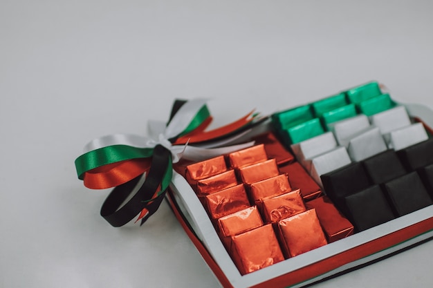 Decoraciones de regalo del día nacional de los Emiratos Árabes Unidos Caja de dulces de color en blanco vacía sobre la mesa blanca