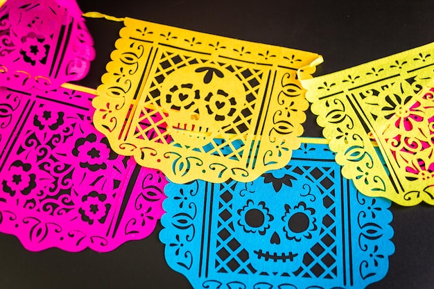 Decoraciones para la tradicional fiesta mexicana del Día de los Muertos sobre un fondo negro.