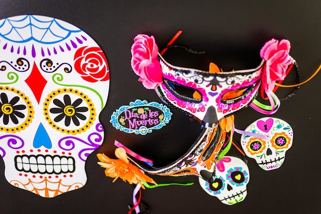 Decoraciones para la tradicional fiesta mexicana del Día de los Muertos sobre un fondo negro.