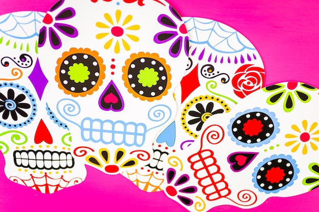 Foto decoraciones para la tradicional fiesta mexicana del día de los muertos sobre un fondo rosa.