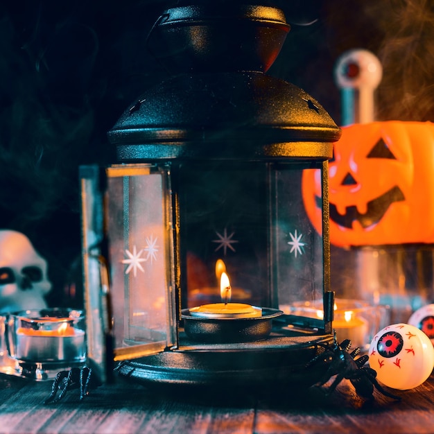 Decorações assustadoras do conceito de Halloween com vela acesa e suporte de vela com fumaça de tom verde ao redor de uma mesa de madeira escura