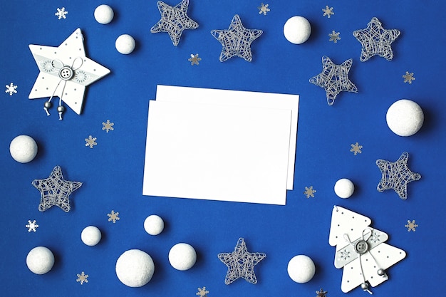 Foto decorações brancas e prateadas planas sobre fundo azul clássico com espaço de cópia. plano de fundo de natal na cor clássica azul com enfeites de prata e branco, plano de fundo de natal com lista de desejos