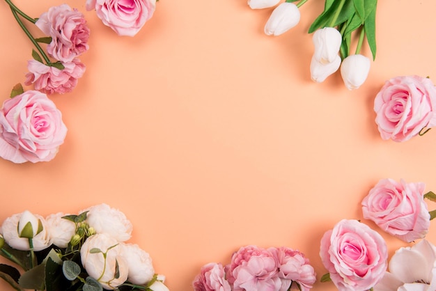 Decorações coloridas t com flores da primavera na vista superior do espaço de cópia de fundo laranja