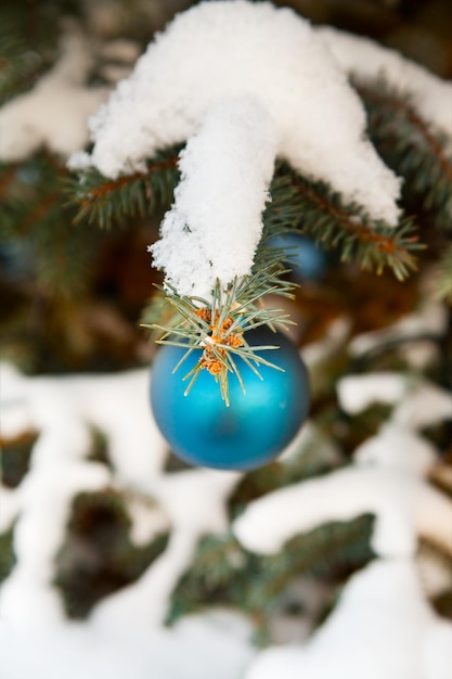 Decorações de árvore de natal na árvore sob a neve ao ar livre