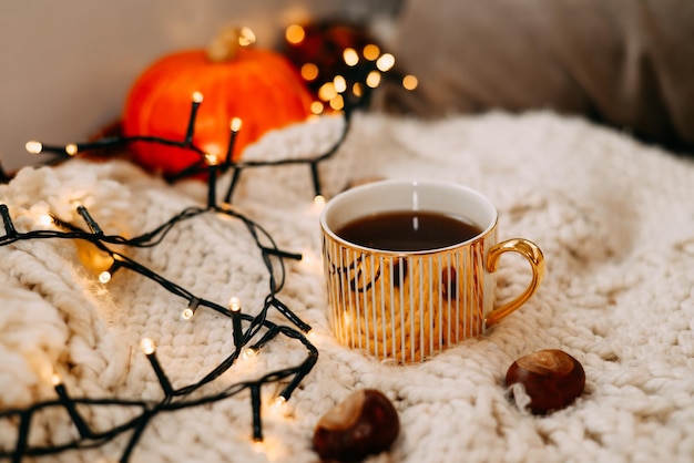 Decorações de casa aconchegantes no interior com manta de tricô e caneca na sala de estar