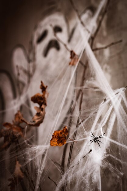 Decorações de Halloween teia de aranha branca no fundo de um fantasma pintado em giz na parede de um quarto escuro à noite verticalmente horror boo