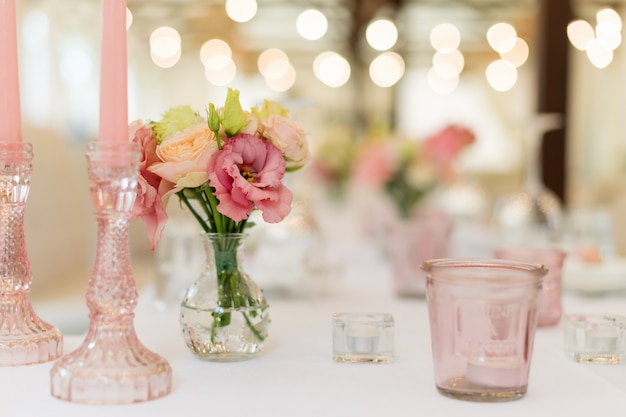 Decorações de mesa de flores para férias e jantar de casamento. Mesa posta para recepção de casamento de férias no restaurante ao ar livre.