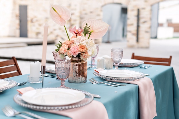 Decorações de mesa de flores para férias e jantar de casamento. Mesa posta para recepção de casamento de férias no restaurante ao ar livre.
