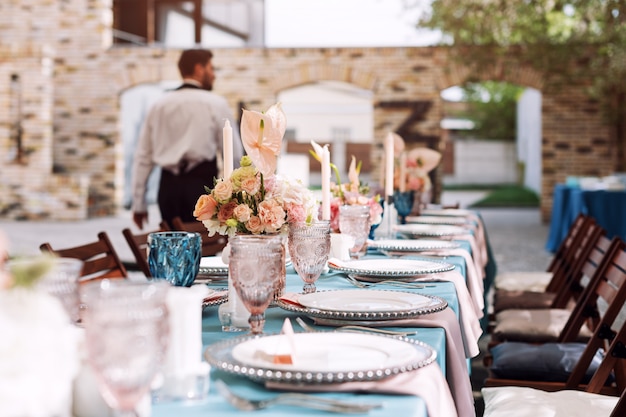Decorações de mesa de flores para férias e jantar de casamento. Mesa posta para recepção de casamento de férias no restaurante ao ar livre.