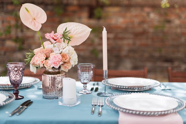 Decorações de mesa de flores para férias e jantar de casamento. Mesa posta para recepção de casamento de férias no restaurante ao ar livre.