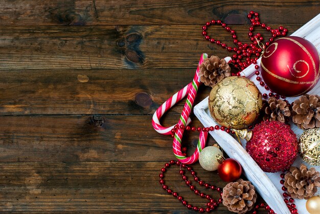 Decorações de Natal, bastões de doces, máscara, colisões na mesa de madeira