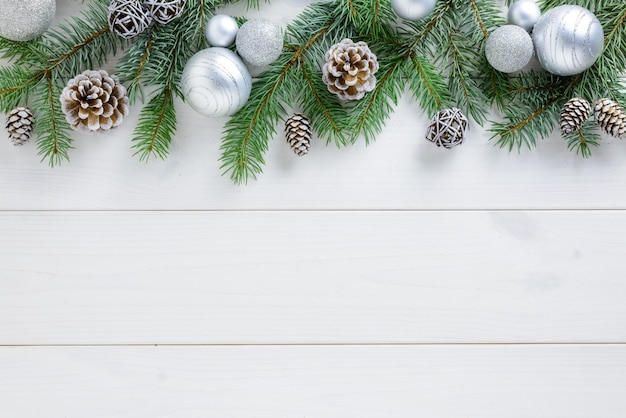 Decorações de Natal, bolas brancas e pinhas em uma mesa de madeira branca. Vista superior, copie o espaço.