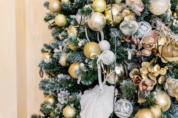 Decorações de natal de cor bonita pendurado na árvore de natal com brilho brilhante. decorações para casa de ano novo, bolas douradas, árvore festiva decorada com guirlanda, enfeites, celebração tradicional
