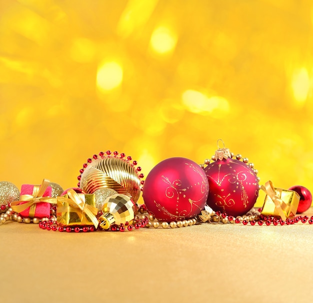 Foto decorações de natal douradas e vermelhas sobre um fundo dourado