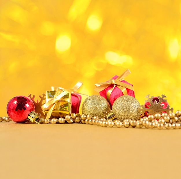 Decorações de natal douradas e vermelhas sobre um fundo dourado