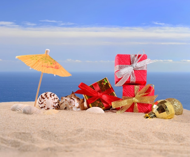 Decorações de Natal e conchas na areia da praia contra o fundo do mar