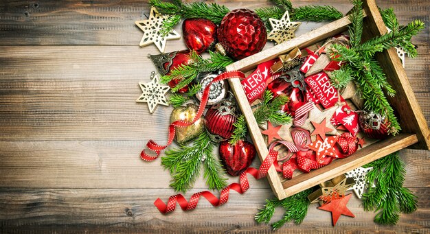 Decorações de Natal e enfeites com galhos de árvores de Natal. Estrelas vermelhas, enfeites, fitas. Imagem em tons de estilo vintage