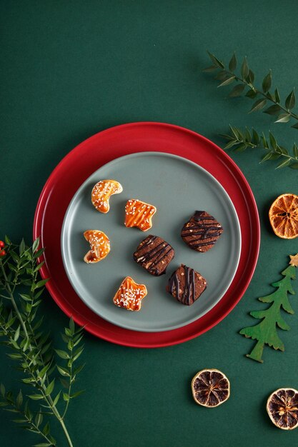 Decorações de Natal e flores em um fundo verde isolado biscoitos em um prato