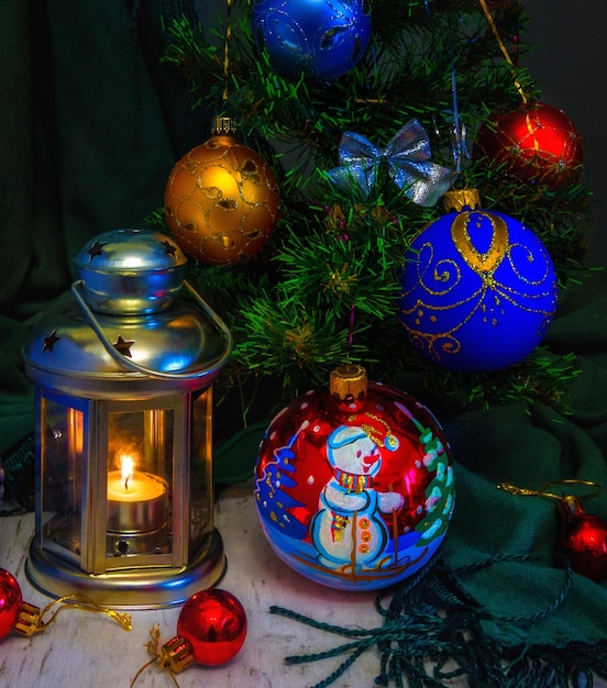 Decorações de Natal e uma vela acesa em uma lanterna. natureza morta de ano novo