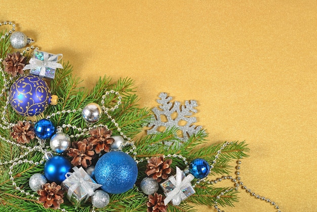 Decorações de Natal em um galho de abeto em um fundo dourado