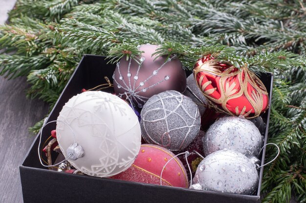 Decorações de Natal em uma caixa parcialmente coberta por galhos de pinheiro.