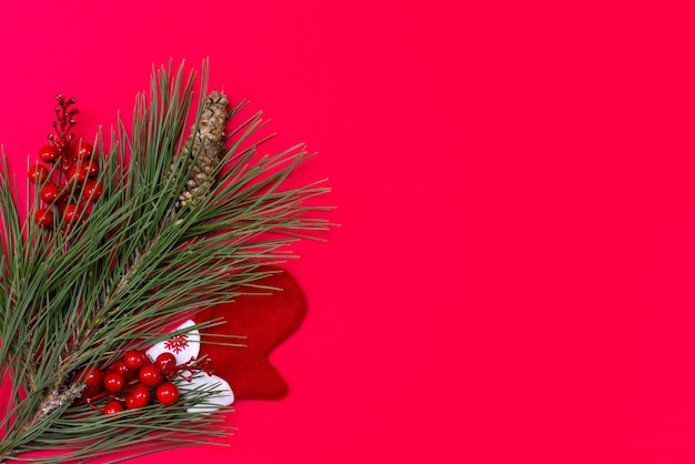 Decorações de Natal em uma vista superior de fundo vermelho. Árvore de Natal, pinha, luva. Copie o espaço