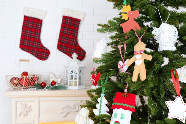 Decorações de Natal feitas à mão na árvore de Natal com luz de fundo interior em casa