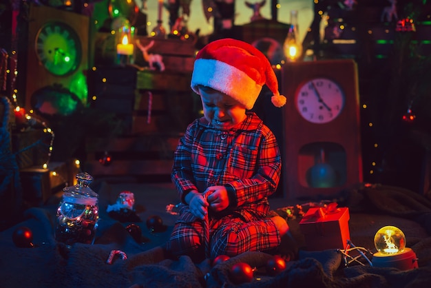 Decorações de Natal. Um menino frustrado está sentado no chão.