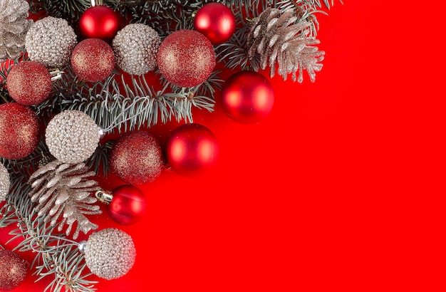 Decorações de Natal vermelhas, galhos de árvores de abeto e bolas sobre fundo vermelho. copie o espaço