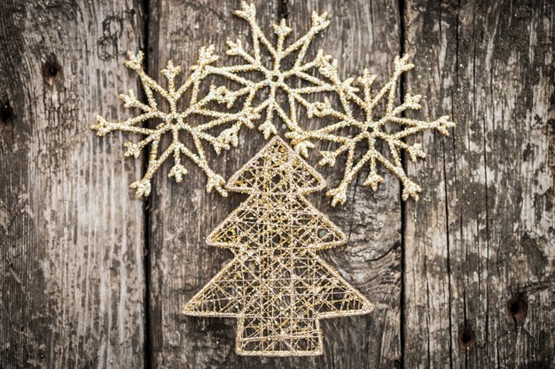 Foto decorações de ouro para árvores de natal em fundo de madeira grunge conceito de férias de inverno