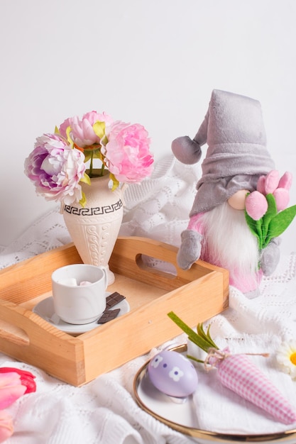 Decorações de páscoa em cima da mesa decoração de mesa coelho cenoura pintada ovos e um buquê de flores em uma bandeja