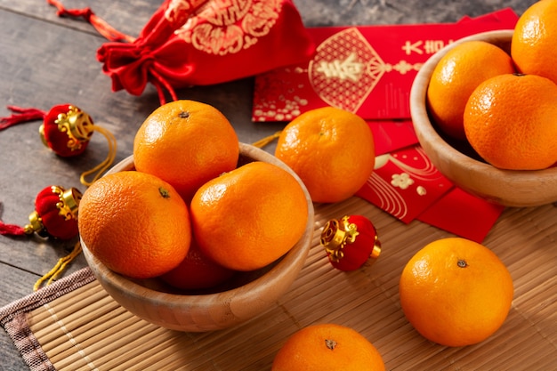 Decorações do festival de ano novo chinês e laranjas em fundo de madeira