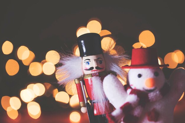 Decorações festivas de boneco de neve e quebra-nozes contra um fundo de luz de fada bokeh