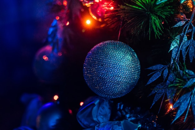 Decorações na árvore de Natal com bolas, guirlandas brilhantes