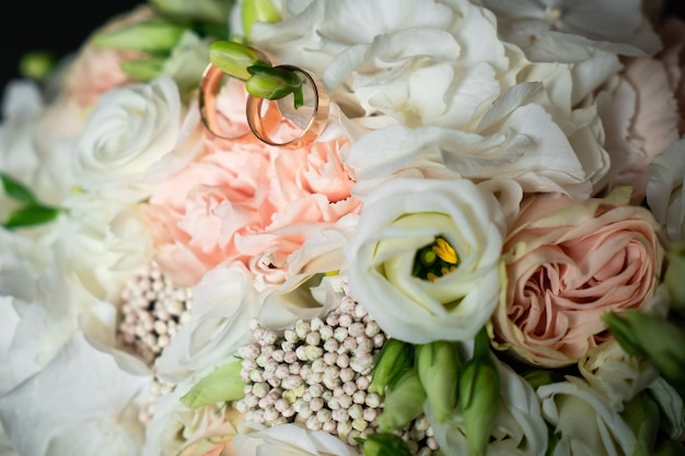 Decorações românticas, flores brancas para o feriado, alianças de casamento para a noiva