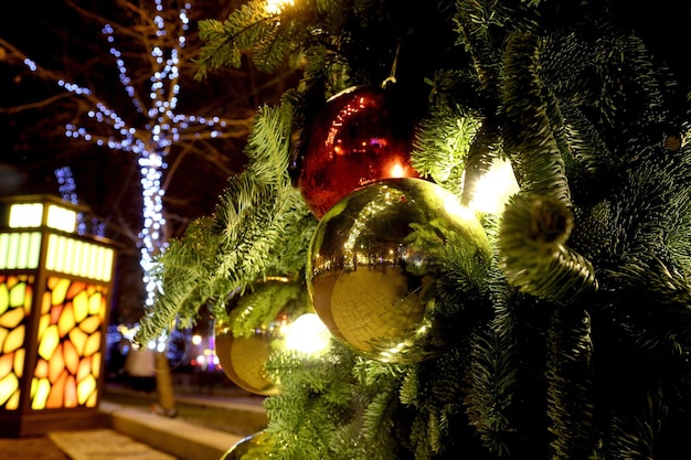 Decorado con adornos de árbol de Navidad en la calle con iluminación.